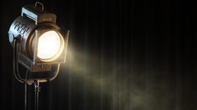 vintage theatre spot light on black curtain with smoke