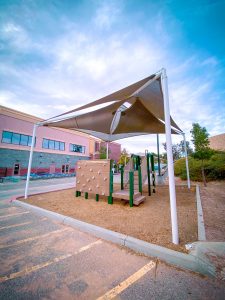 SCVi shade structure in play area behind school building