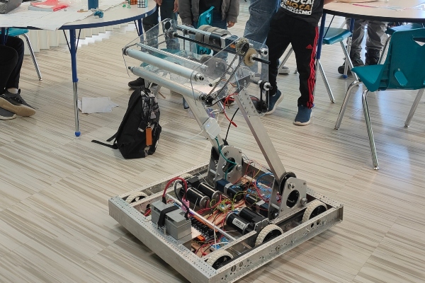 Bueford, SCVi's robot, is pictured in a classroom with younger students looking at him.