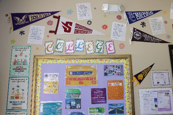 Santa Clarita Valley International Charter School classroom wall decorated with pennants from colleges. Purple bulletin board sharing college information and the word “College” above it.