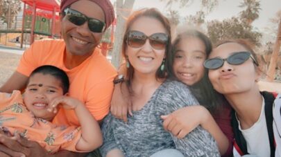 Santa Clarita Valley International (SCVi) student Elise Martinez’s family sits outside and smiles for the camera, one child sitting on an adult’s lap and everyone else lining up.